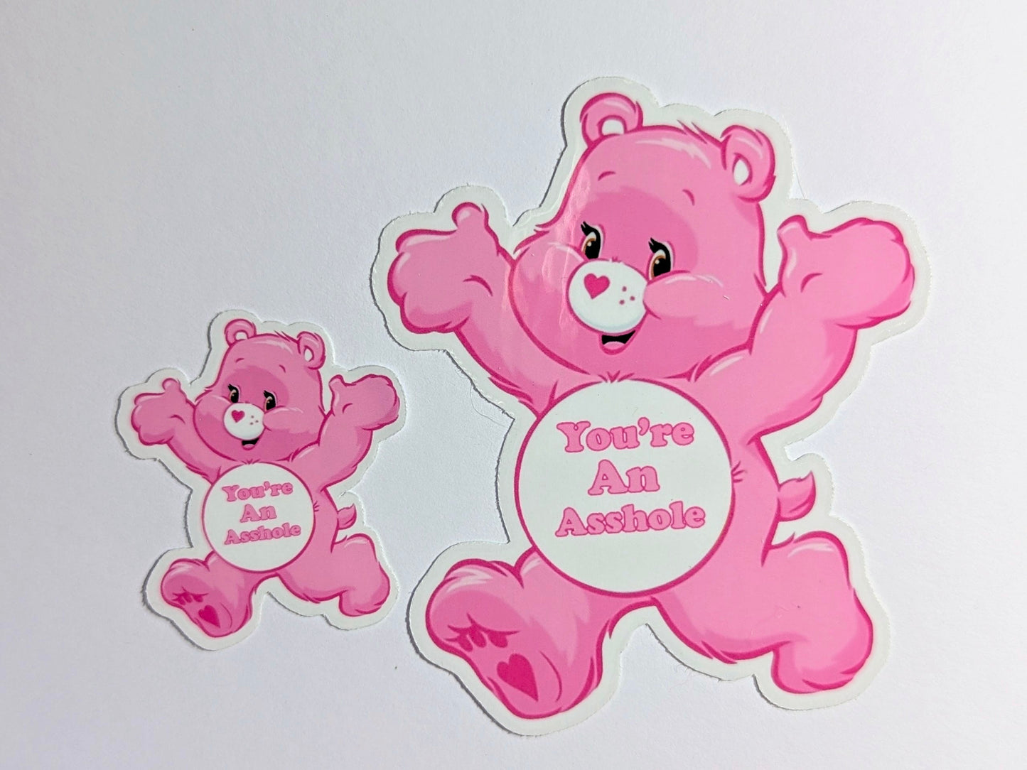 Two pink bears with offensive text on a white background