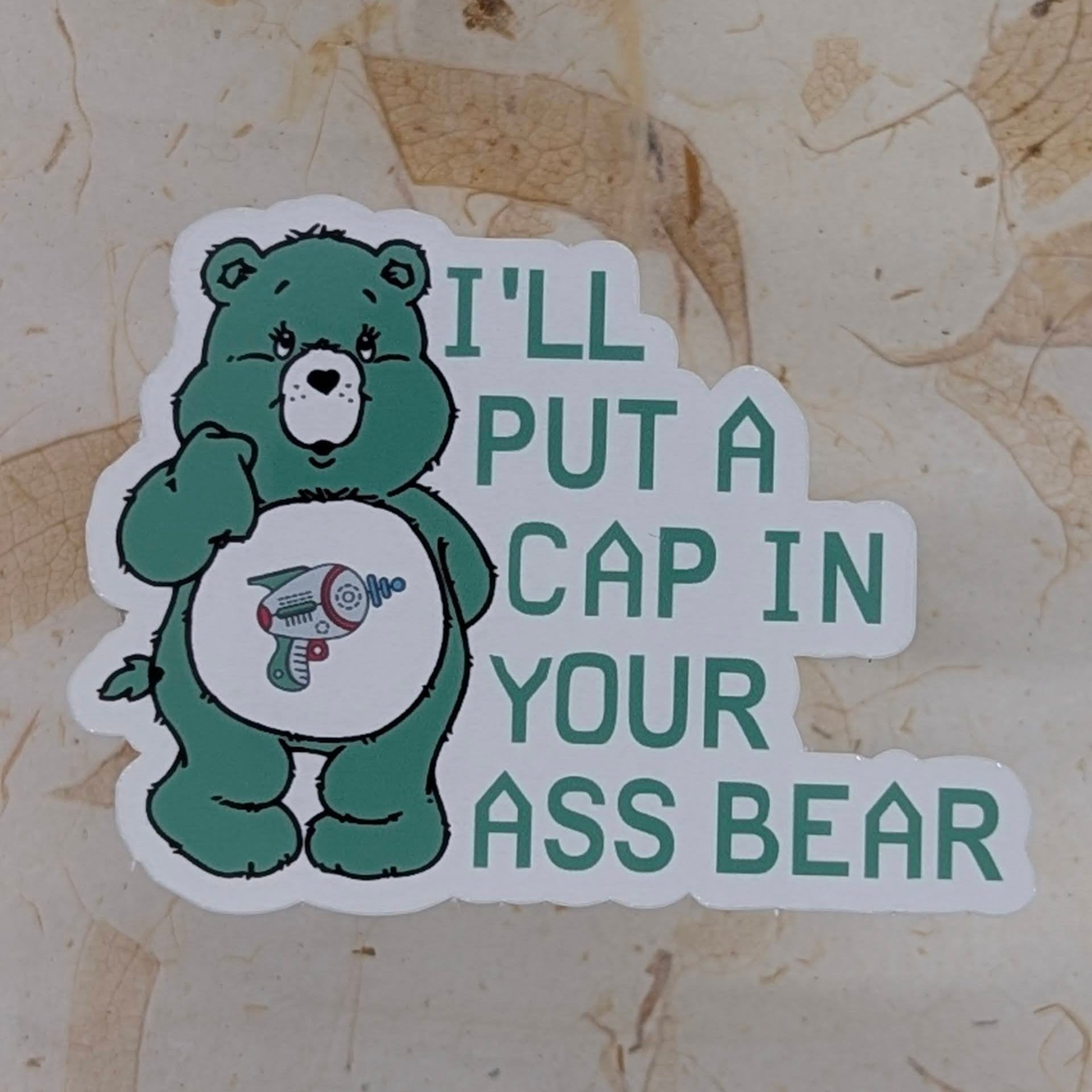Sticker with a green bear character and text on a textured beige background