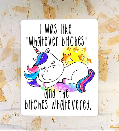 A rectangular white sticker or print with a cartoon unicorn and bold black text reading, 'I was like "whatever bitches" and the bitches whatevered.' The unicorn is white with a blue, pink, and purple horn and tail, surrounded by yellow stars, placed on a light marble-like surface.