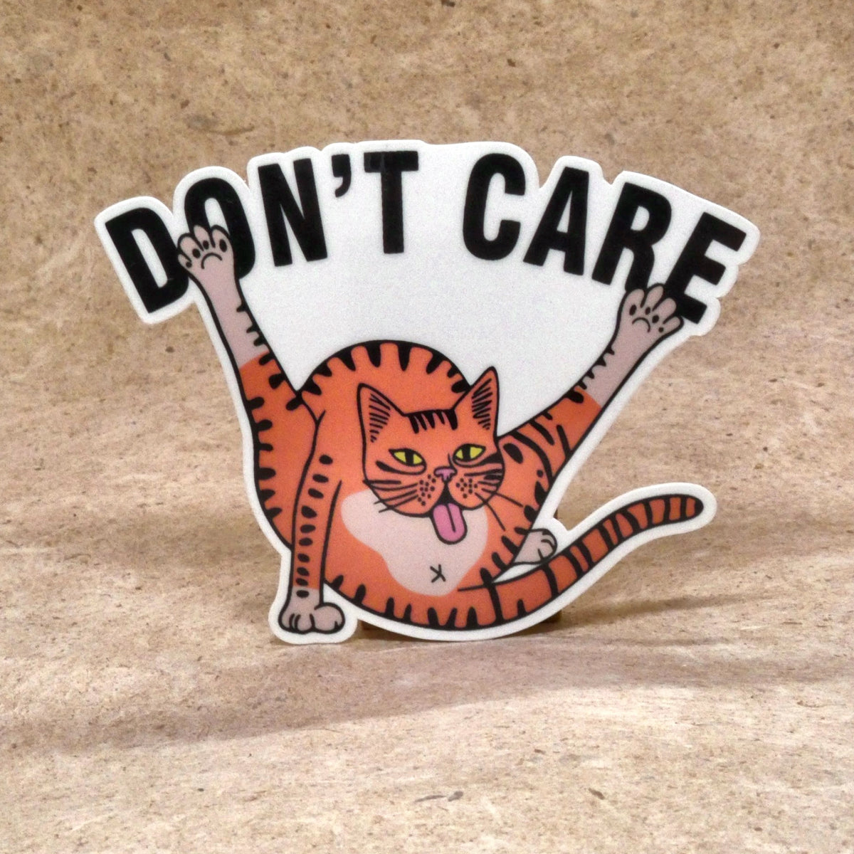 Don't Care orange tabby cat die-cut vinyl sticker, real product photo