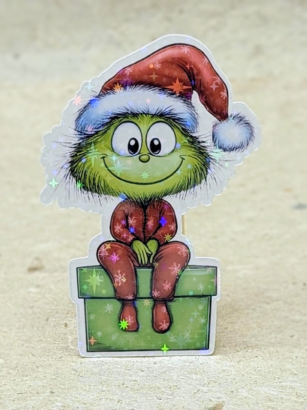 Holographic baby green Christmas critter sitting on a present sticker