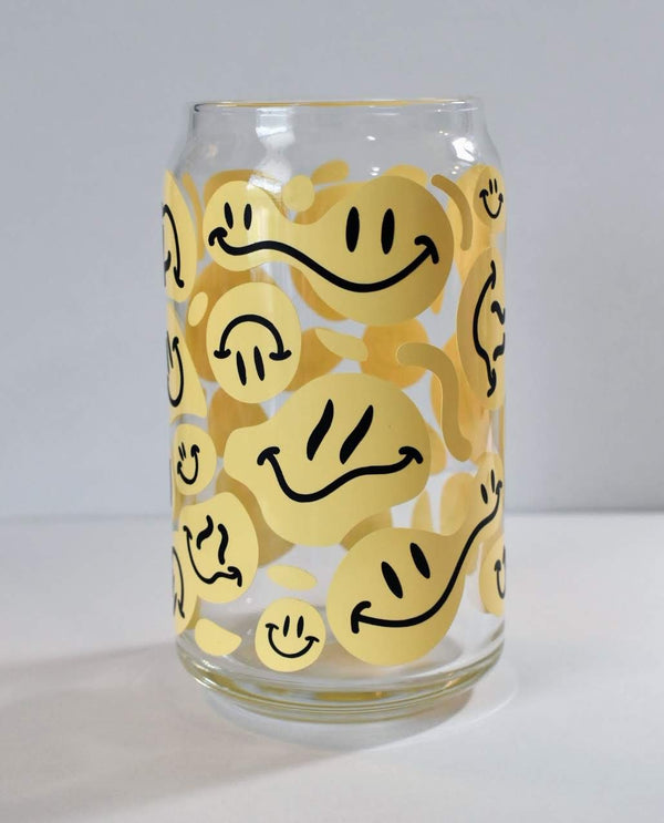Yellow melting smiley face vinyl decals on a clear glass can cup