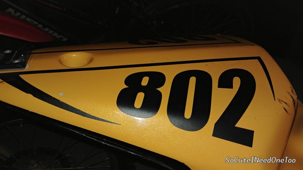 Black custom race number vinyl decal on a yellow dirt bike