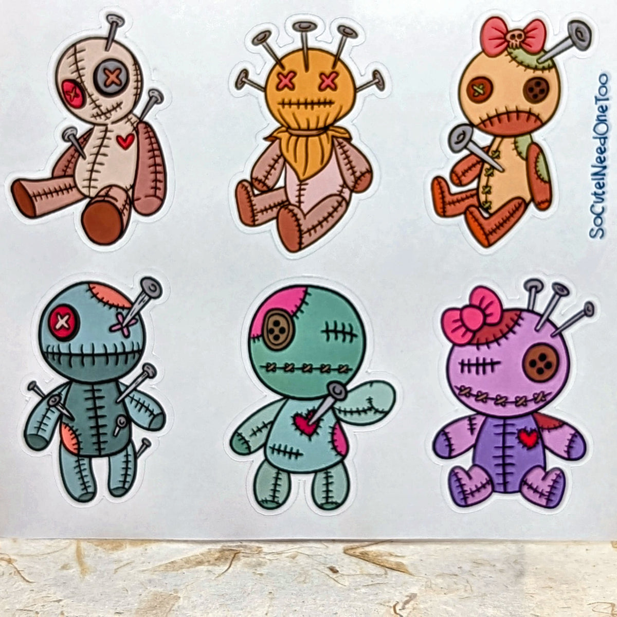 Close-up of six voodoo doll stickers including bow dolls, real product photo