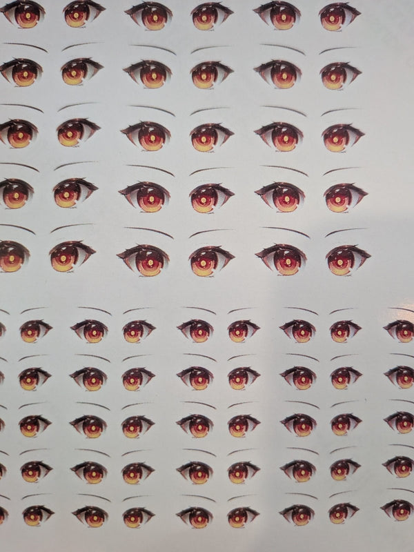 Sheet of red and gold anime-style doll eye waterslide decals in two sizes